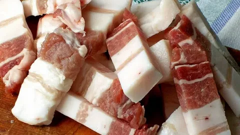 Slănină de porc proaspătă tăiată în cuburi pe un fund de lemn, sursă de acizi grași pentru sistemul nervos